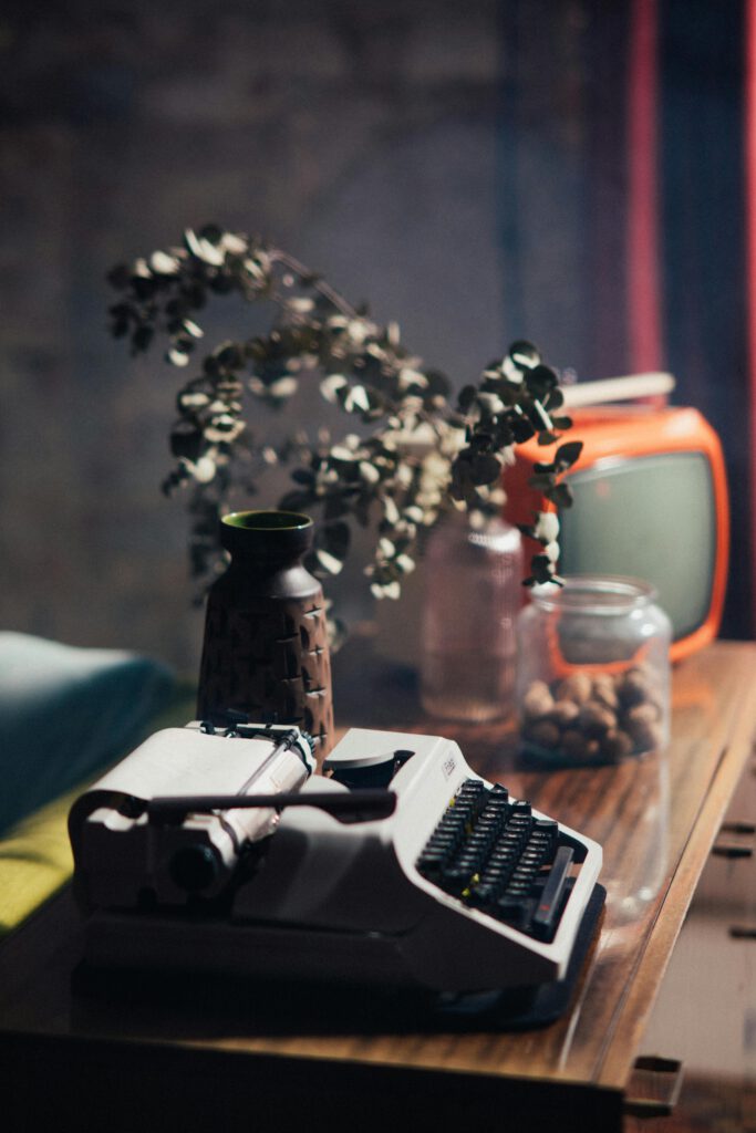 pexels photo 7689333 7689333 Classic still life with a vintage typewriter and retro decor on a wooden table.